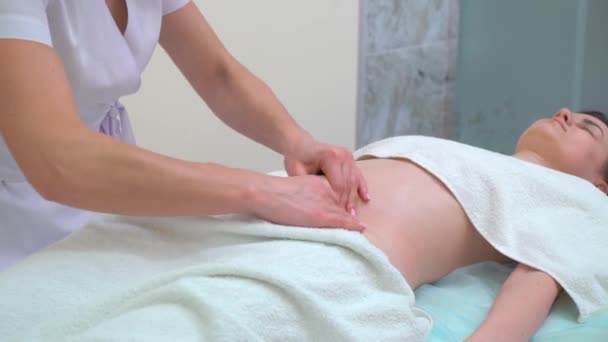 Tilt up shot of female masseur doing anti cellulite massage on woman abdomen — Stock Video