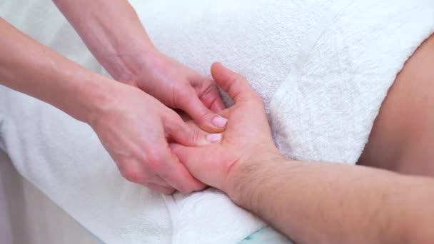 Kvinnliga händer gör palm avslappnande massage för manlig patient i terapeutiska rummet — Stockvideo