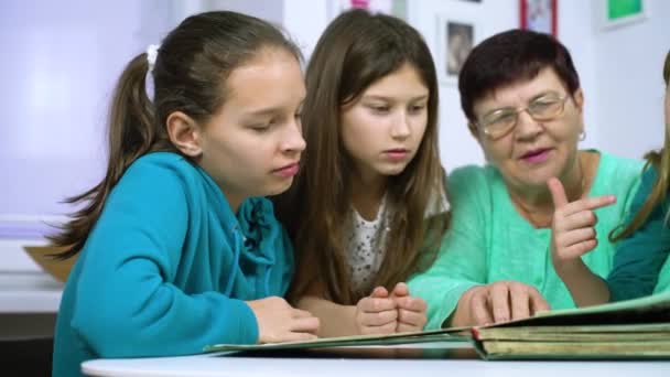 Meninas assistindo álbum de fotos antigo com sua avó — Vídeo de Stock