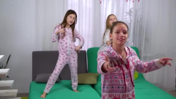 Три девушки в пижаме танцуют дома — стоковое видео