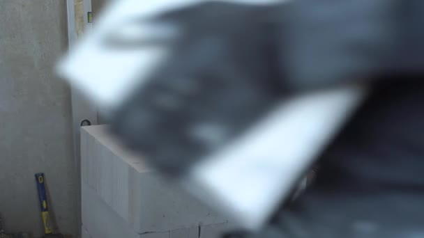 Обрізаний знімок будівельника в брудній роботі носіння блоків на будівельному майданчику — стокове відео