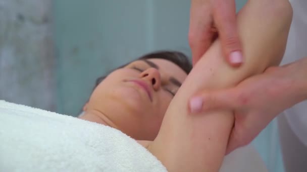 Женские руки массируют плечо молодой женщины для лечения целлюлита — стоковое видео