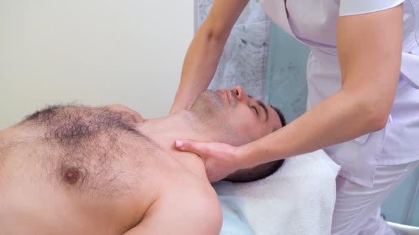 Terapeuta femenina masajeando hombros y cuello del cliente masculino en el salón de spa — Vídeos de Stock