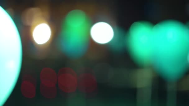 Розмиті повітряні кулі, освітлені барвистими прожекторами в святковому інтер'єрі — стокове відео