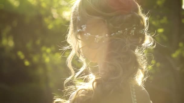 Back view of bride with hair wreath in sunny garden with free space — Stock Video