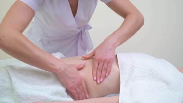 Plan incliné vers le haut du masseur féminin massant l'abdomen de la jeune femme — Video