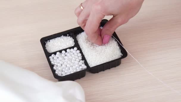 Nahaufnahme von Frauen Hände String Perlen auf Nadel und nähen sie zu Spitzenstoff — Stockvideo