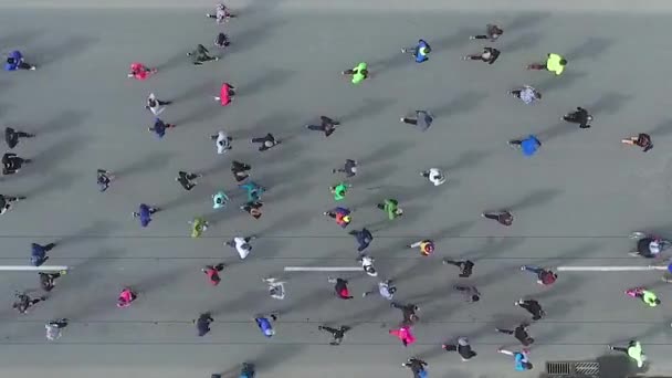 Plano aéreo de arriba hacia abajo de los corredores de maratón en carretera asfaltada — Vídeo de stock