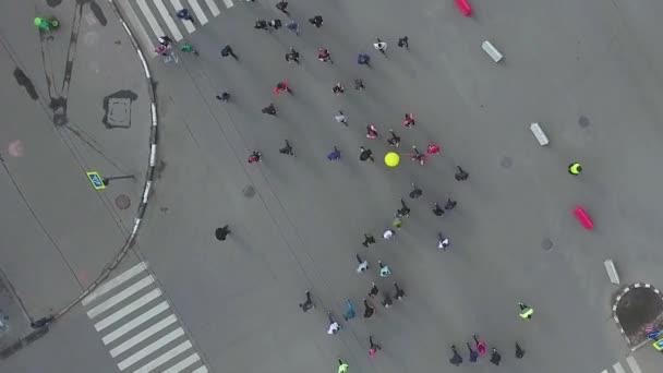 Tiro aéreo de cima para baixo do cruzamento da estrada com as pessoas que correm na maratona da cidade — Vídeo de Stock