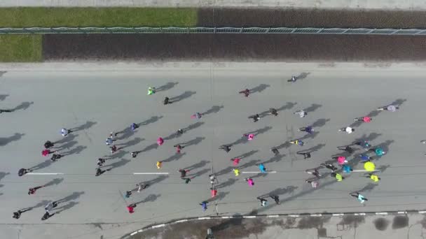 Top down aerial shot of marathon runners compete on city road — Stock Video