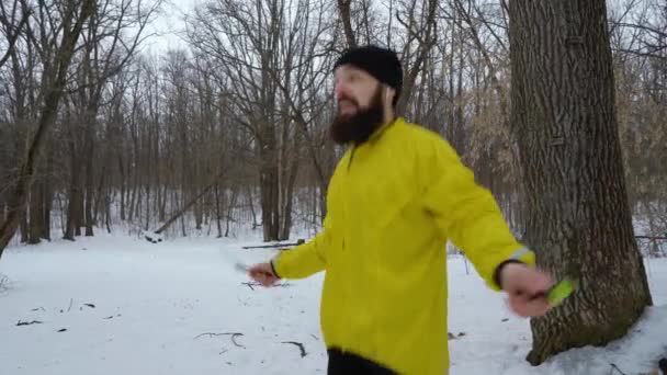 Бородатый спортсмен прыгает с скакалкой в зимнем лесу — стоковое видео