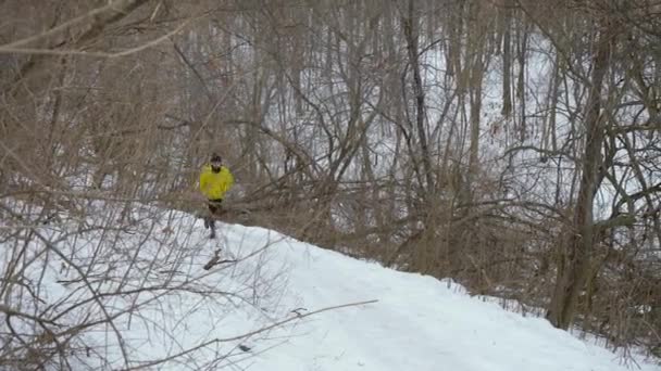 Skäggiga Fit manliga Jogger springa upp backen i vinter skogen — Stockvideo