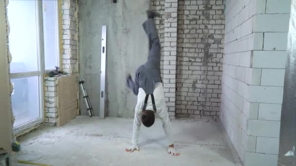 Unga sportig byggare som går på sina händer på bygg arbets platsen — Stockvideo
