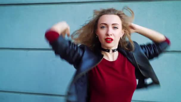 Retrato de mujer rubia bonita bailando contra pared texturizada gris al aire libre — Vídeo de stock