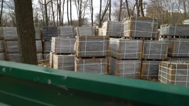 Pilas de adoquines colocados en el suelo detrás de la valla al aire libre — Vídeo de stock