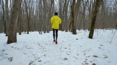 Kış ormanda kar üzerinde çalışan erkek spor adam çekim izleme
