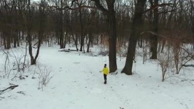 Kış ormanda atlama halat ile sarı ceket atlama sporcunun Arc shot