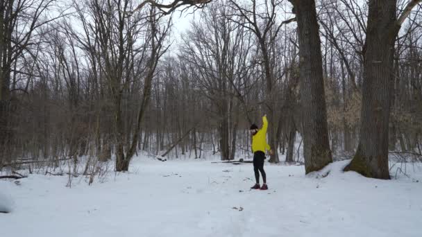 Hombre deportivo masculino calentándose durante las nevadas en el bosque de invierno con espacio libre — Vídeo de stock
