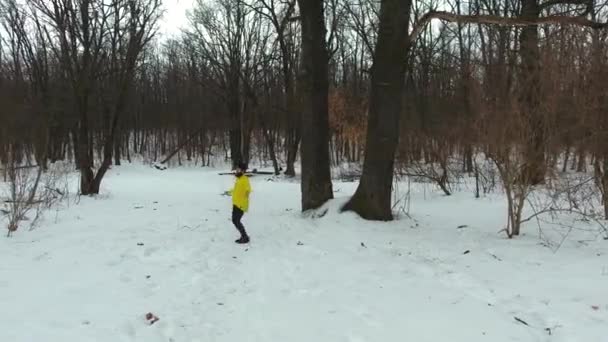 Antenn av skäggiga idrottare i gul kappa hoppar med rep i vinter skogen — Stockvideo