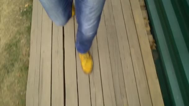 Vista superior de los pies masculinos caminando sobre cubierta de madera en el sitio de construcción — Vídeo de stock