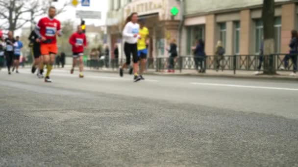 Размытые марафонцы на улицах города ранней весной — стоковое видео