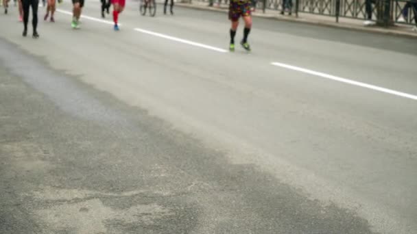 Visão turva de corredores pernas correndo maratona na estrada de asfalto na cidade — Vídeo de Stock