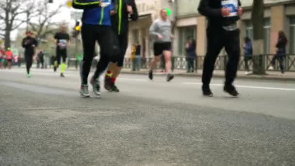Размытая толпа людей, бегущих по асфальтовой дороге на городском марафоне — стоковое видео