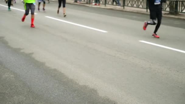 Visão turva de pessoas pés correndo na estrada de asfalto na maratona da cidade — Vídeo de Stock