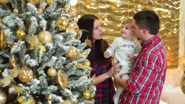 Lycklig familj med liten dotter nära dekorerade julgran hemma — Stockvideo