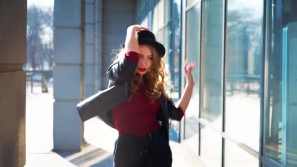 Mulher loira bonita em chapéu sai da coluna e dança à luz do sol — Vídeo de Stock