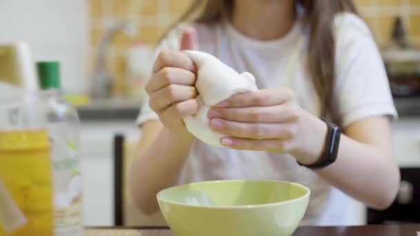 Skupić się na teen girl ręce wyciskając i rozciąganie biały puszysty szlam — Wideo stockowe
