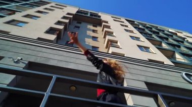 modern binanın yakınında performans sarışın kadın sokak dansçısı düşük açı çekim