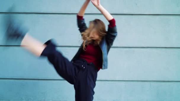 屋外で灰色のテクスチャーの壁に対して実行する美しい女性ダンサー — ストック動画