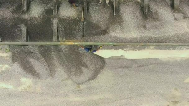Вид сверху вниз на разгрузку промышленных щебня из грузового вагона — стоковое видео