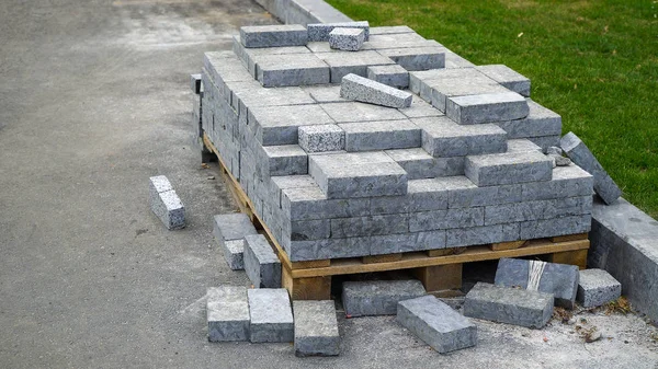 kaldırım taşları yığını yeşil çim yakın ahşap palet üzerinde yatıyor