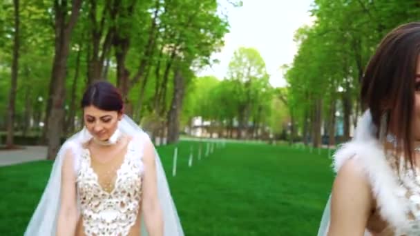 Female dancers in luxurious costumes and bridal veils perform in city park — Stock Video