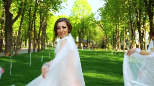 Сексуальные танцовщицы в гламурных костюмах и вуали выступают в солнечном парке — стоковое видео