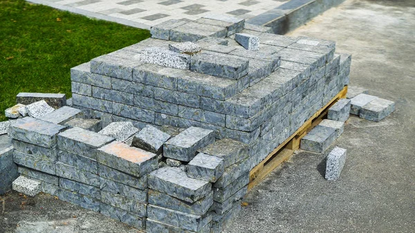 gri kaldırım taşları şehir parkında yeşil çim yakın ahşap palet üzerinde saklanır