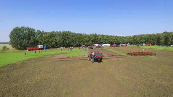 Sumy, Ucrania - Sep 12, 2017: aérea de tractor rojo esparciendo fertilizantes artificiales en campo arado — Vídeo de stock