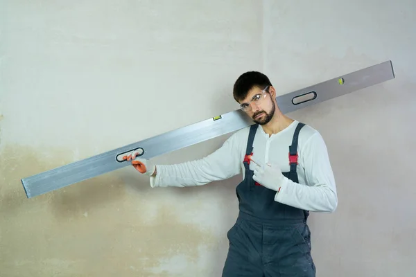 İnşaat cetvelli genç müteahhit iç boşlukta işaret parmağı gösteriyor