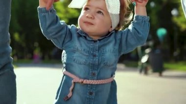 ebeveynleri ile güneşli parkta yürüyen yürümeye başlayan kız stepping ayakları görünümü