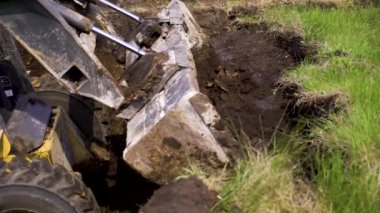 toprak işleri sırasında çimenli toprak tabakası kaldırma mini yükleyici kısmi görünümü