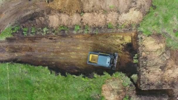 Haut vers le bas de bulldozer creuser fosse de fondation pour la maison neuve dans la campagne — Video