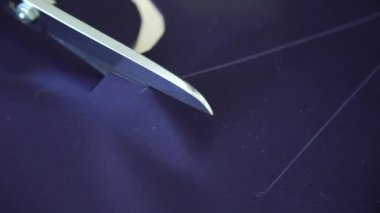 genç kadın ellerinin yakın çekim desen göre makas ile mavi kumaş kesilmiş