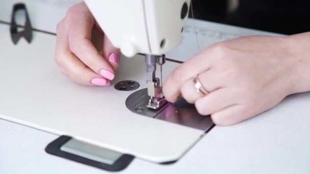 Closeup of young woman hands threading an eye of needle in a sewing machine — Stock Video