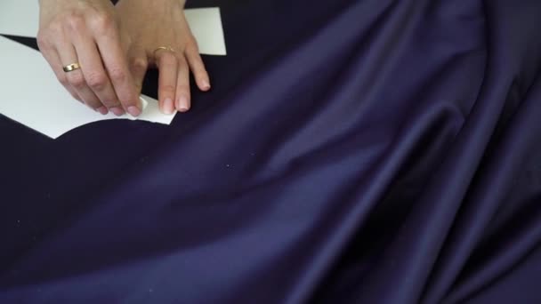 Primer plano de las manos pulcras de la plantilla de dibujo sastre femenino en la tela con tiza — Vídeos de Stock