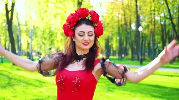 Fröhliche junge Frau in Tracht im Folk-Stil tanzt draußen mit Linsenschlageffekt — Stockvideo