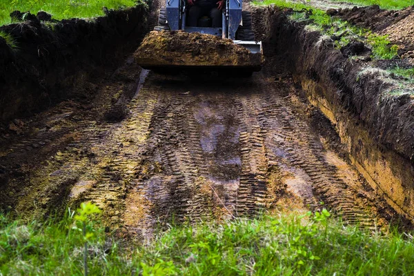toprak işleri sırasında çimenli toprakta çukur kazma ekskavatör lastikleri izleri