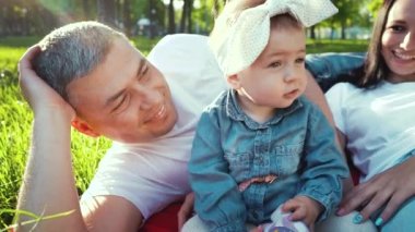 lens parlama ile yaz parkında yeşil çim ebeveynleri ile sevimli bebek kız