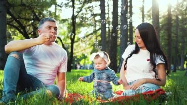 kız bebek sabun kabarcıkları üfleme yaz parkında zaman harcama ile mutlu aile